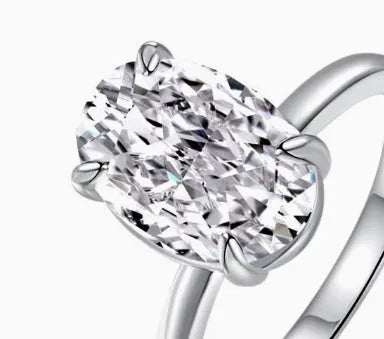 Oval women's ring with four-claw setting holding a 6x9mm gemstone on a silver band