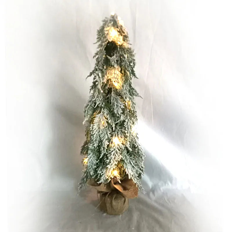 Small white 24-inch plastic Christmas tree with LED lights and simulated snow spray on desktop