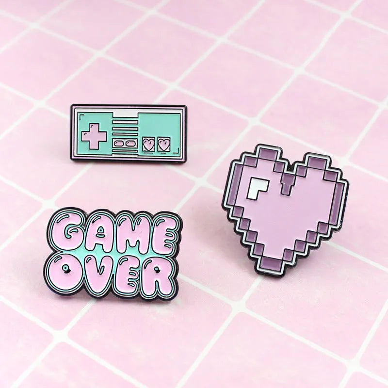 Stereo game console design metal badge with pin back, shown in one of three alloy colour options.
