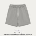 Baby boy and girl wearing loose-fit cotton denim shorts in charcoal grey and cream apricot colours.