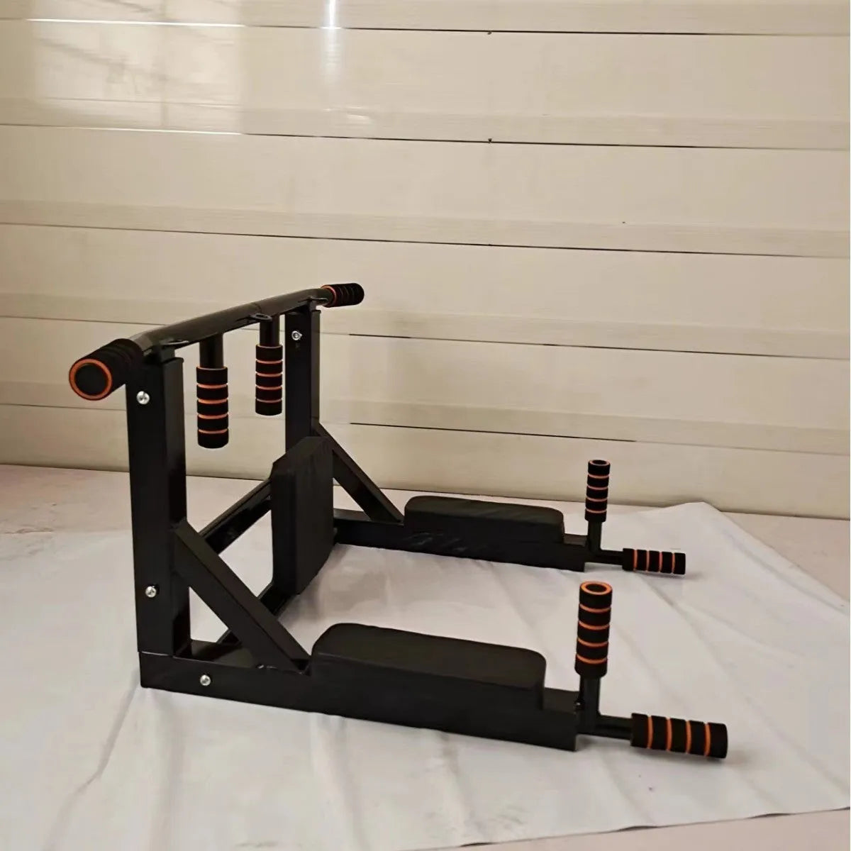 Black steel wall-mounted fitness rack with parallel bars and a sandbag hook.