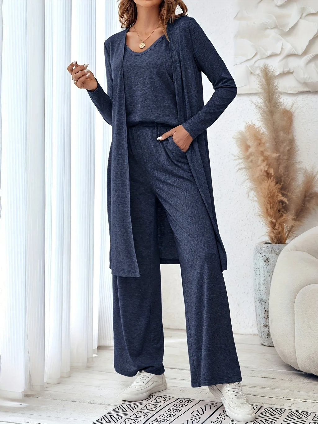 Blue women's three-piece casual suit with cardigan, top, and trousers on a hanger.