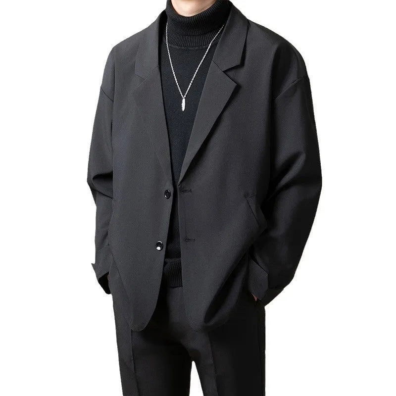Man wearing a loose-fitting apricot-coloured casual suit jacket with long sleeves.