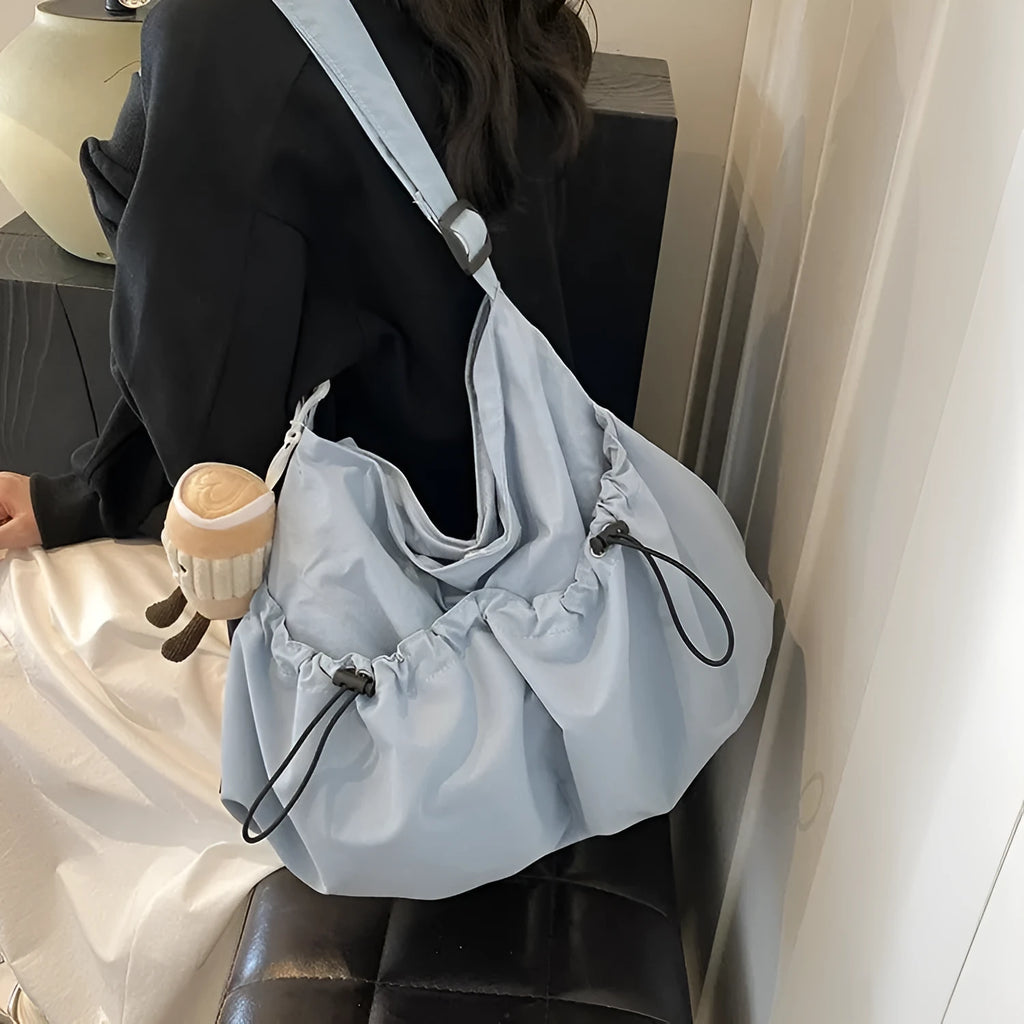 Green ultra-light pleated crossbody cloth bag showing split pocket and foldable design.