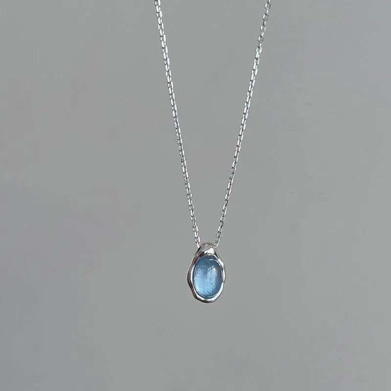 Navy blue and white gold geometric water drop pendant necklace on a cross chain for women.