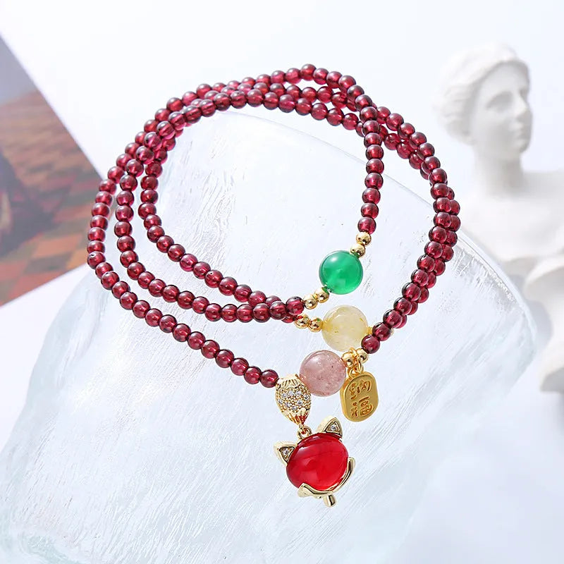 Purplish red garnet crystal fox bracelet on an adjustable rope for women.