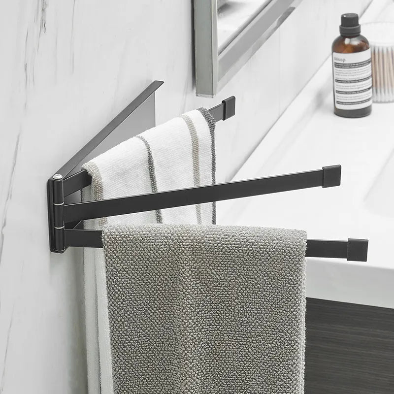 Black folding towel bar mounted on a bathroom wall with no visible screws or drill holes.
