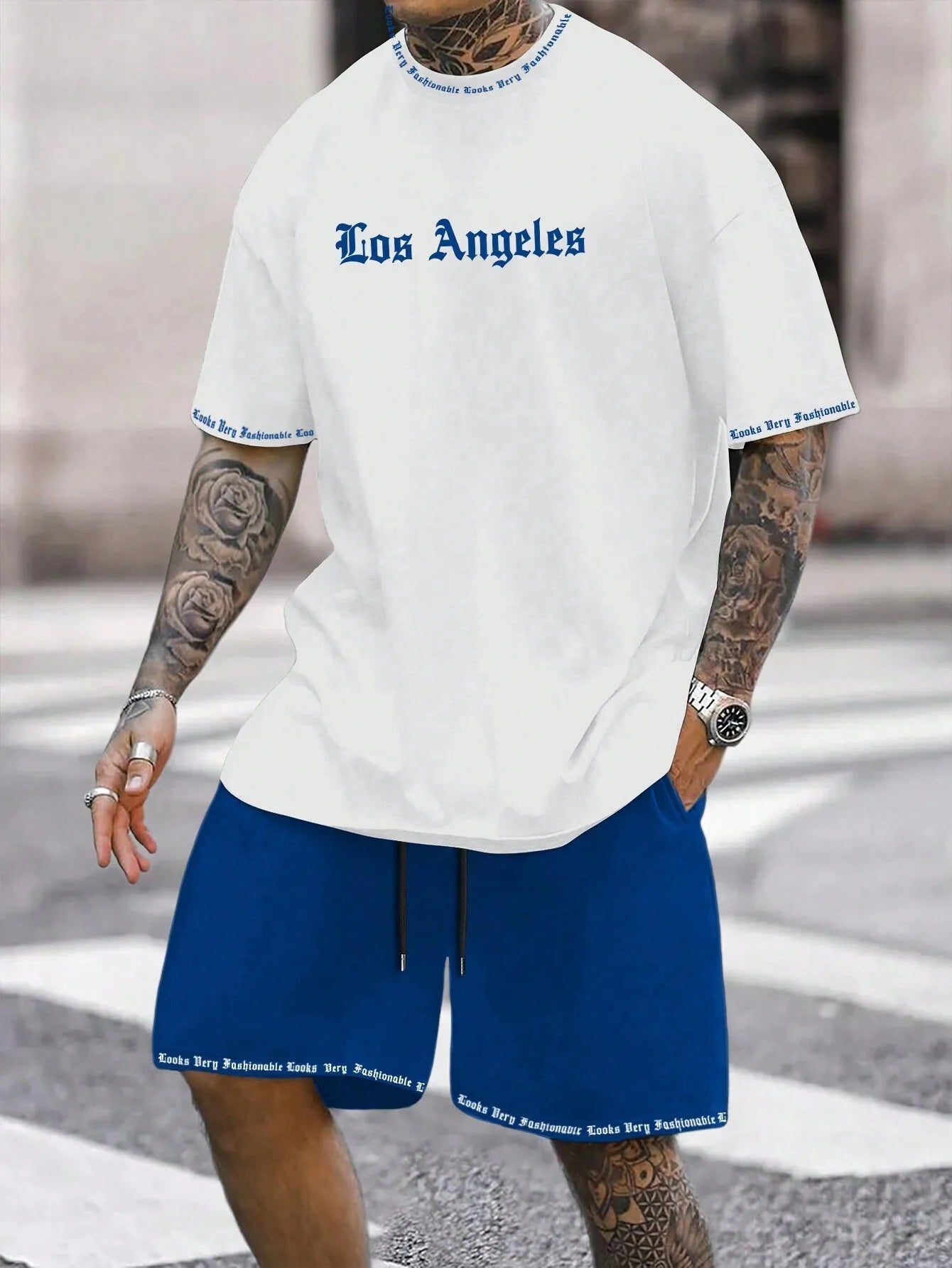 Man wearing a blue printed short-sleeved top and matching shorts from a sports-style two-piece set