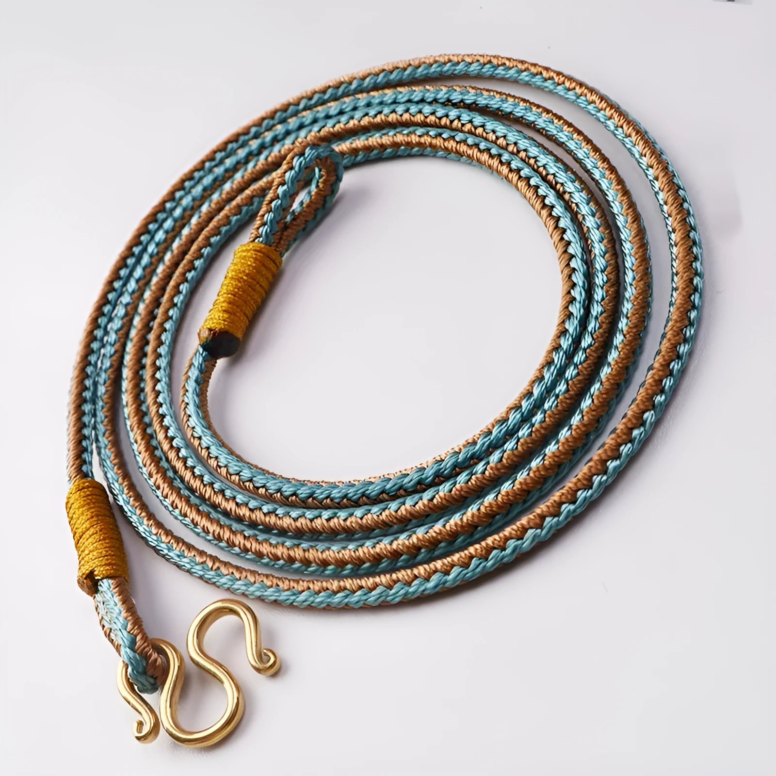 Gold Tibetan Thangka peace buckle necklace with gem inlays on an imitation pearl perimeter.