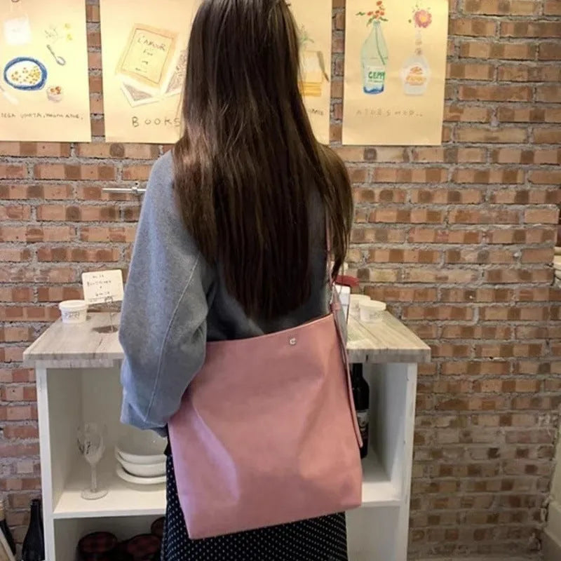 Corduroy one-shoulder commuter bag in pink colour showing textured fabric and structured shape