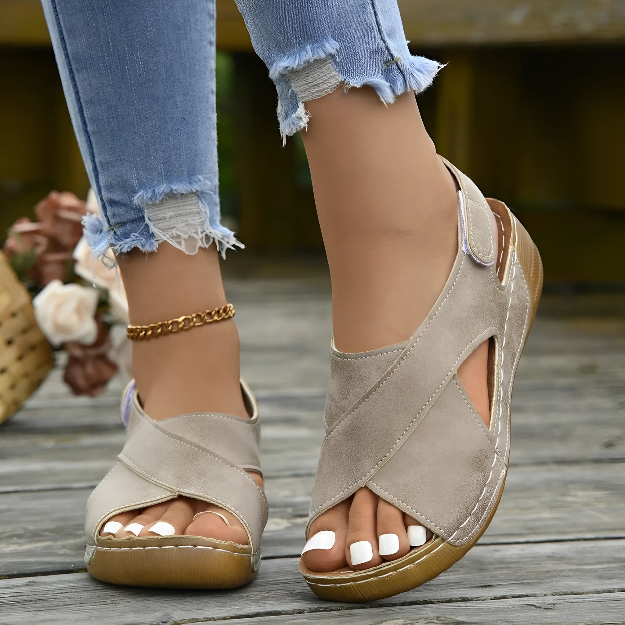Women's beige Roman-style sandals with a fabric skirt detail, platform sole, and Velcro strap.