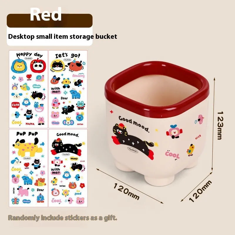 Cartoon-style plastic desktop organiser with grid compartments and labelling stickers for stationery storage