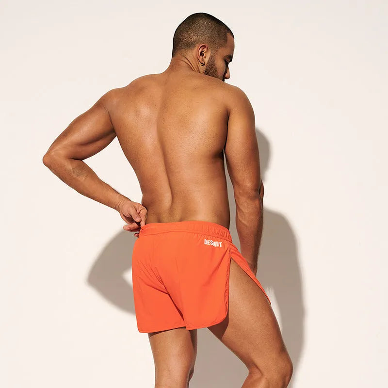 Men's loose beach surfing shorts in orange, fluorescent green, and black colors with elastic waistband