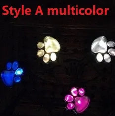 Black solar powered paw print garden lights with four LED lamps connected to a single stake, glowing on a garden path.