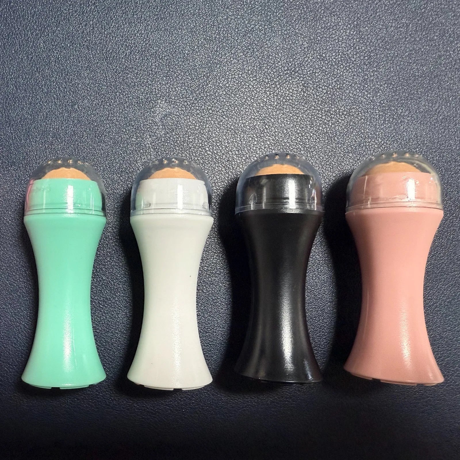 Portable volcanic stone facial roller for oily skin control in black, green, pink, or white