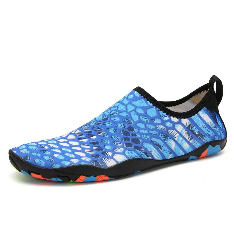 Pair of lycra and EVA water shoes in camouflage colour on a sandy beach