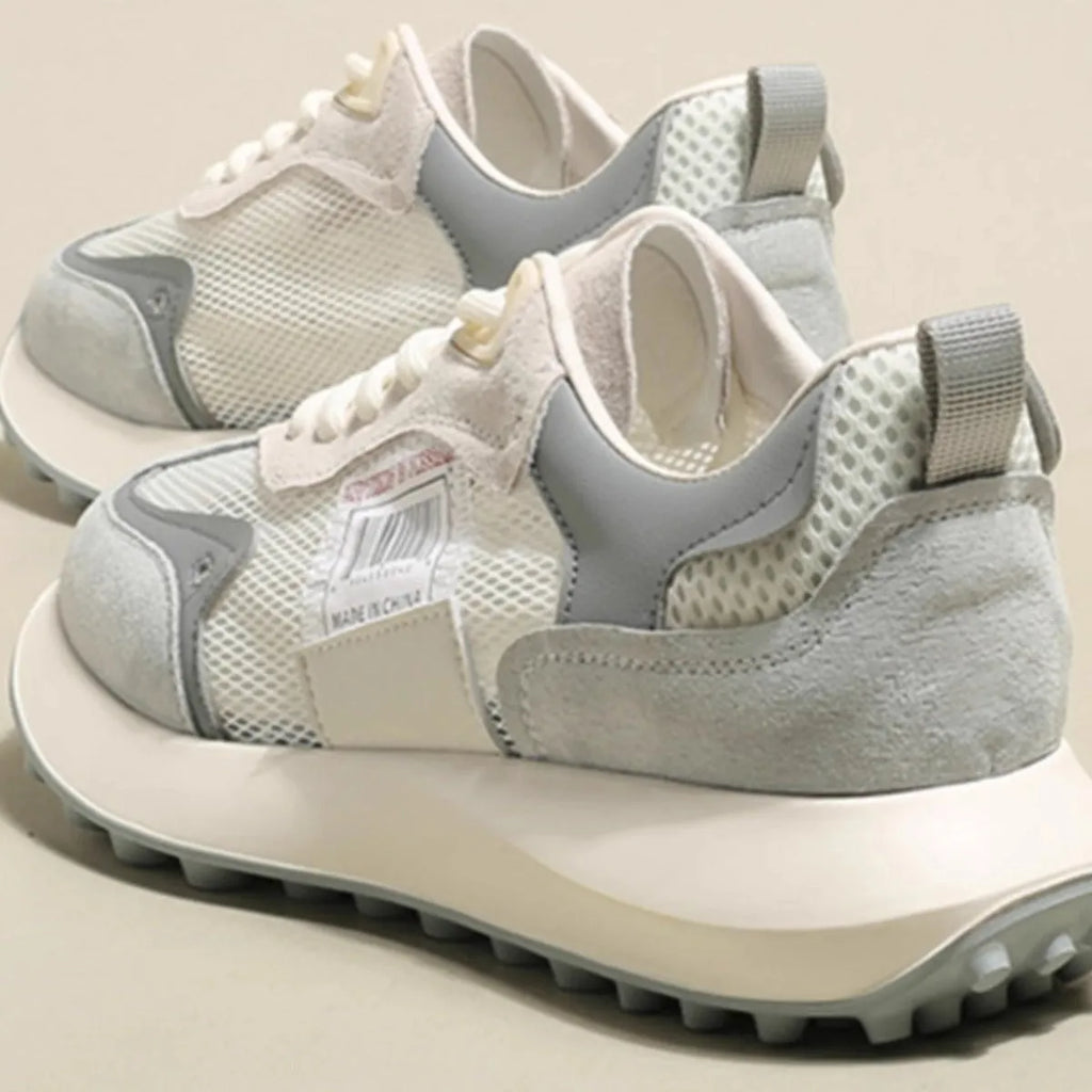 Grey and pink women's low-top retro sneaker with round toe and rubber sole on a white background.