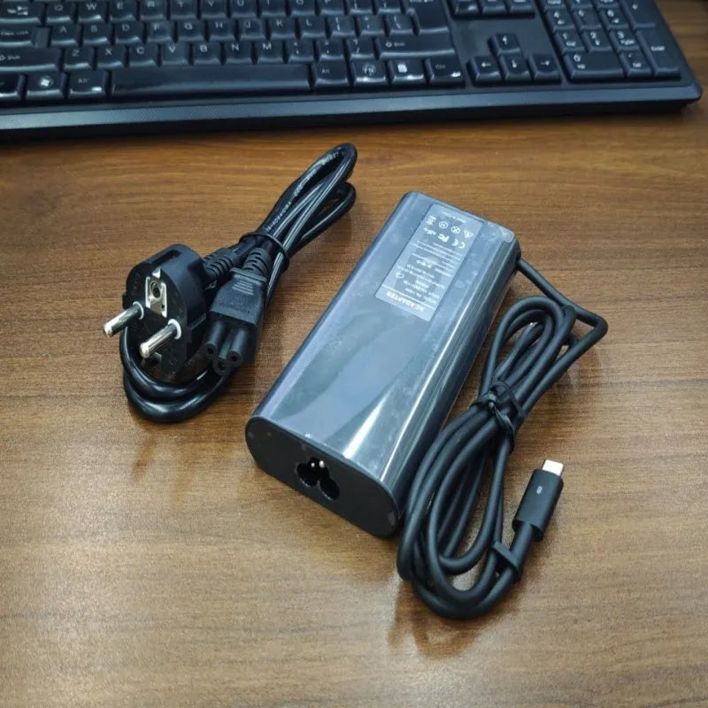 Black 65W USB-C laptop power adapter with six international plug cords for UK US EU AU SA and CN sockets