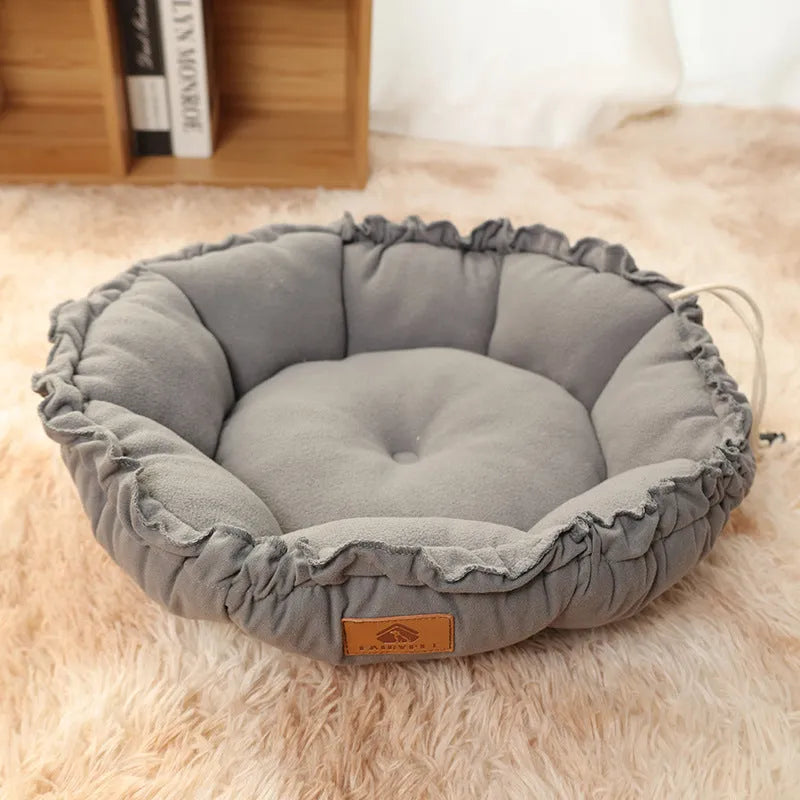 Grey reversible donut-shaped pet bed for cats and small dogs on a floor.