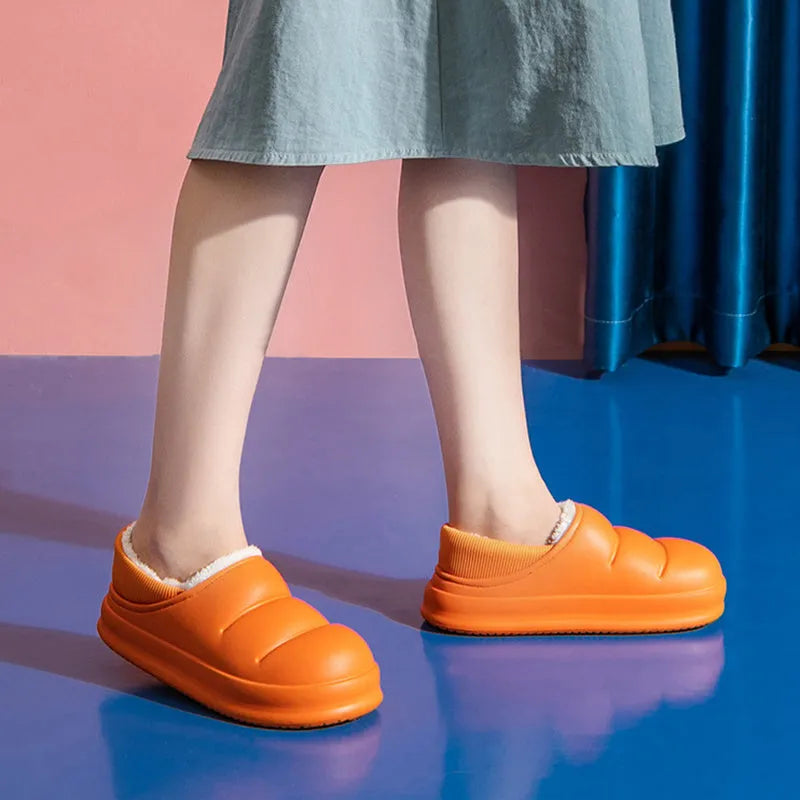 A pair of waterproof EVA couple slippers with a warm plush lining, shown in a green colour option.