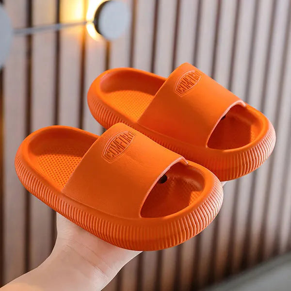 Children's bright coloured EVA slippers with textured non-slip soles, shown in blue, green, orange, pink, and yellow.