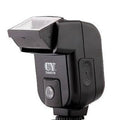 Compact black hot shoe camera flash unit with a head rotated upwards for bounce lighting.