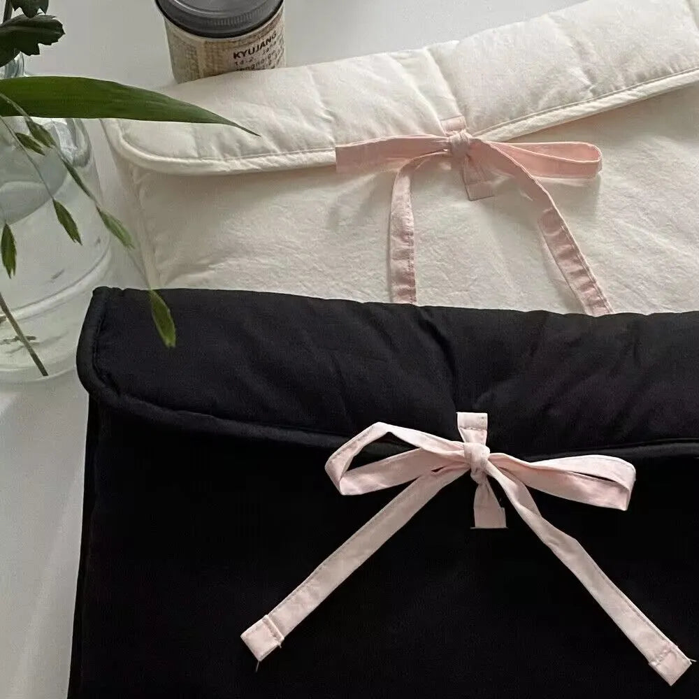 Women's black quilted laptop bag with ballet bow detail and striped pattern
