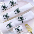 Set of six black alloy napkin rings with spider pattern design for Halloween table decoration