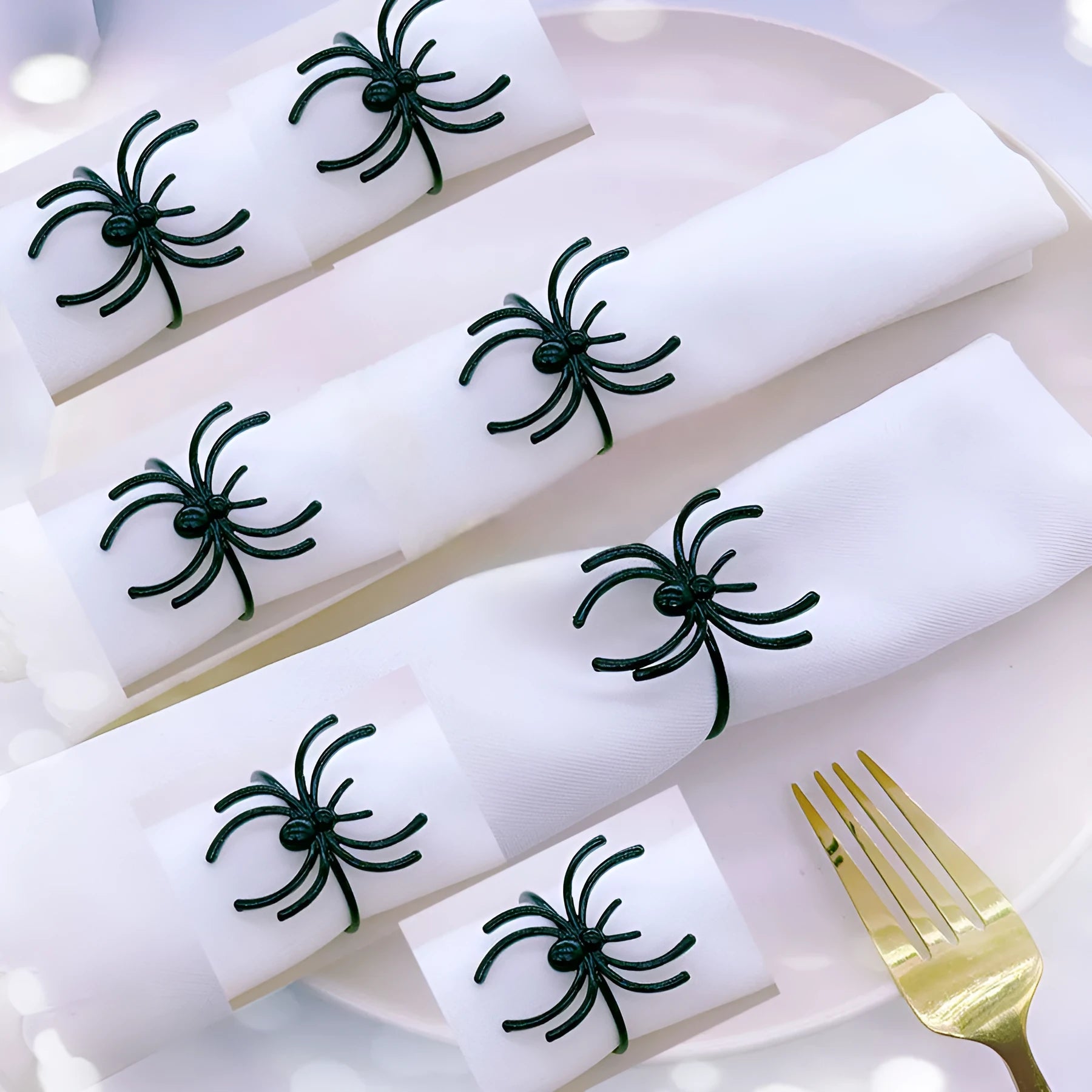 Set of six black alloy napkin rings with spider pattern design for Halloween table decoration