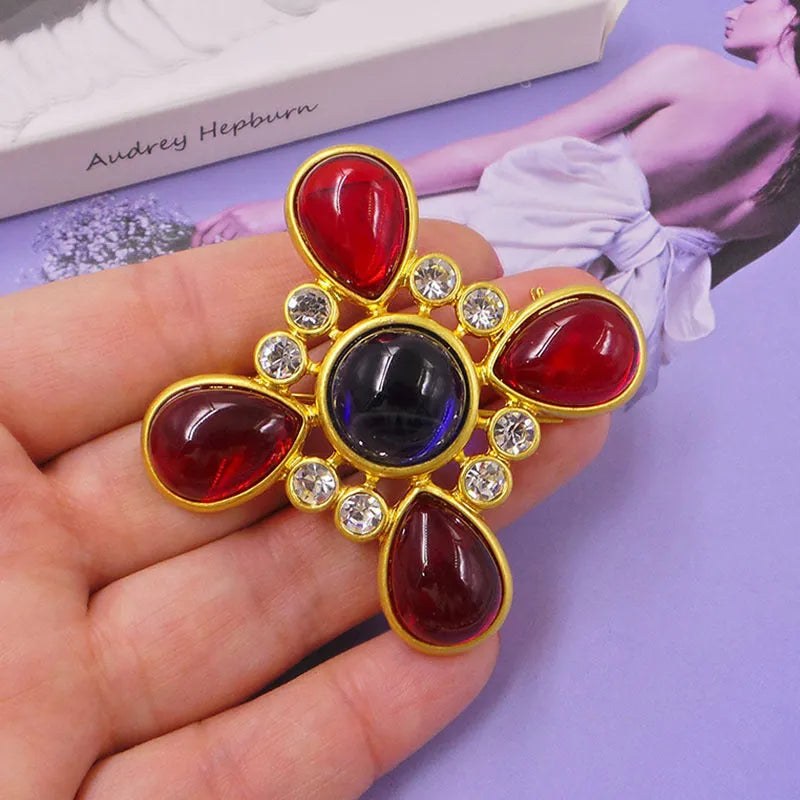 Classic vintage zinc alloy brooch with baroque-style cross design and crystal details on a dark background.