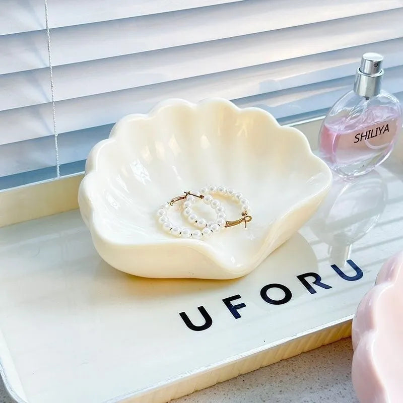 Shell-shaped white plastic soap dish with raised base for bathroom use