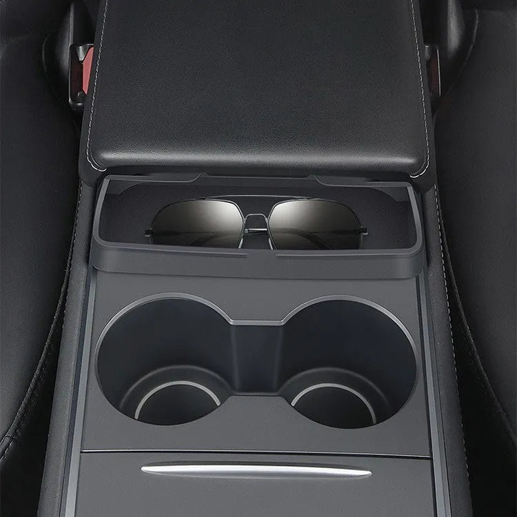 Black silicone glasses storage case accessory installed in a Tesla Model 3 or Y centre console armrest.