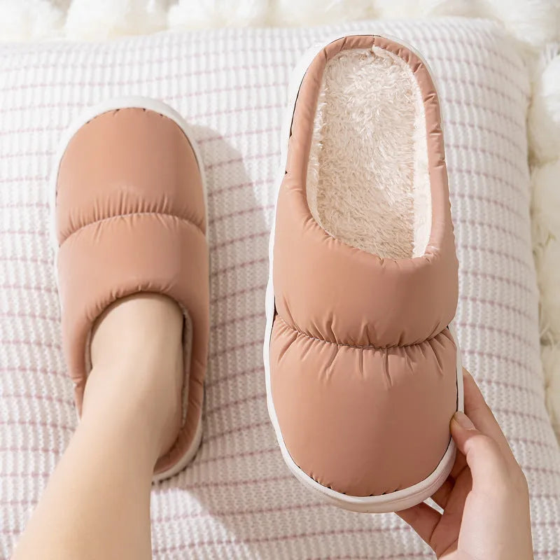 Blue down cotton slippers with artificial leather upper, thick rubber sole, and plush lining shown on a wooden floor.