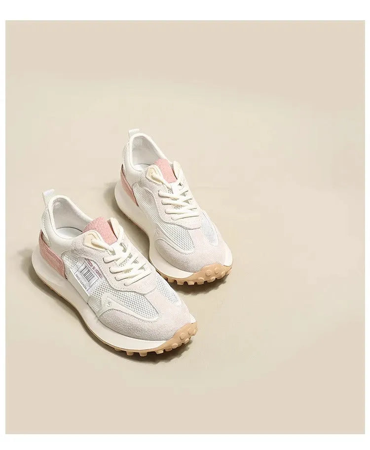 Grey and pink women's low-top retro sneaker with round toe and rubber sole on a white background.