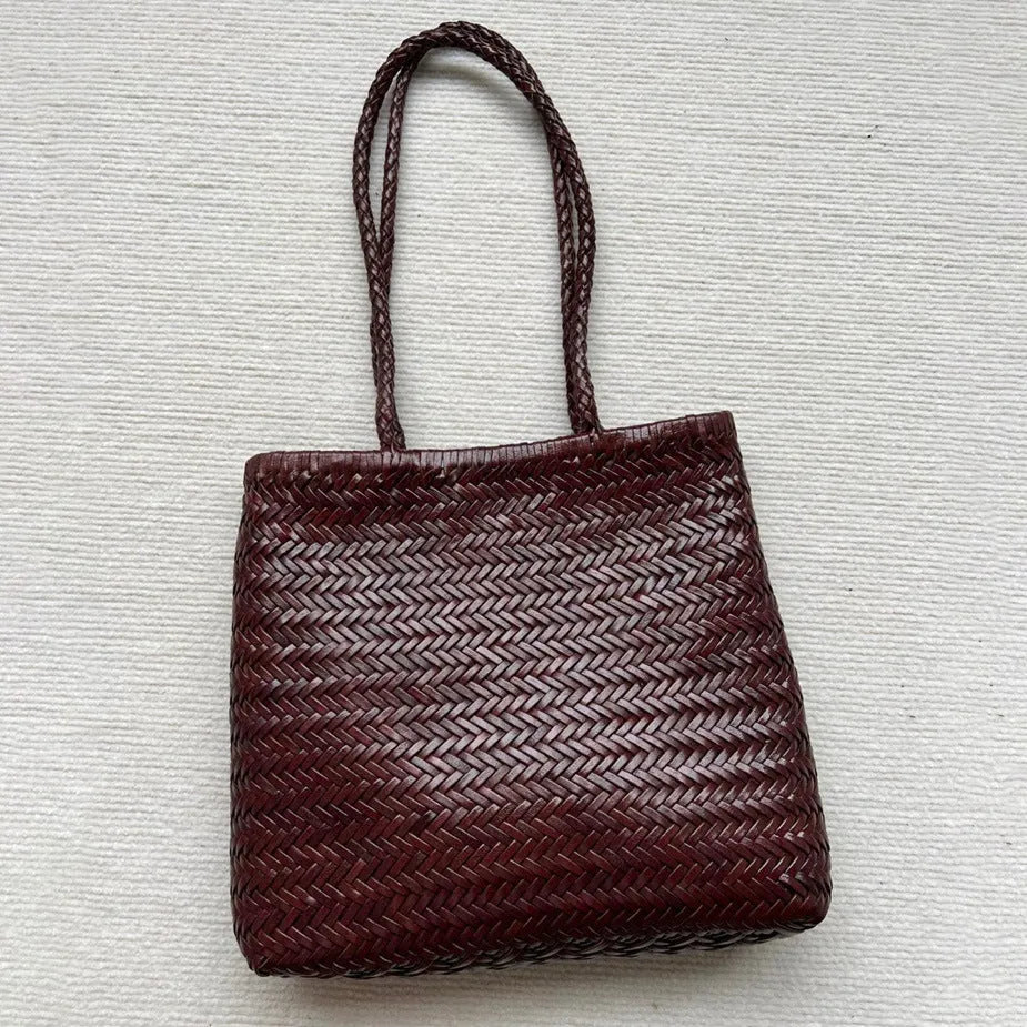 Brown woven genuine leather tote bag with a three-dimensional front pocket.