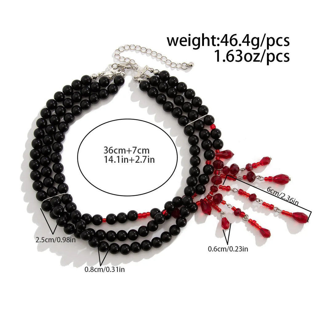 Men's Halloween necklace with red artificial crystal blood drop pendant and black imitation pearl tassels on a metal chain.