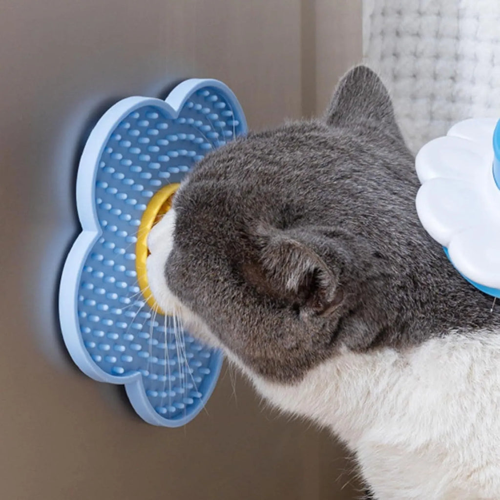 Flower-shaped silicone pet licking mat in blue with suction cups on the back, shown on a tiled surface.