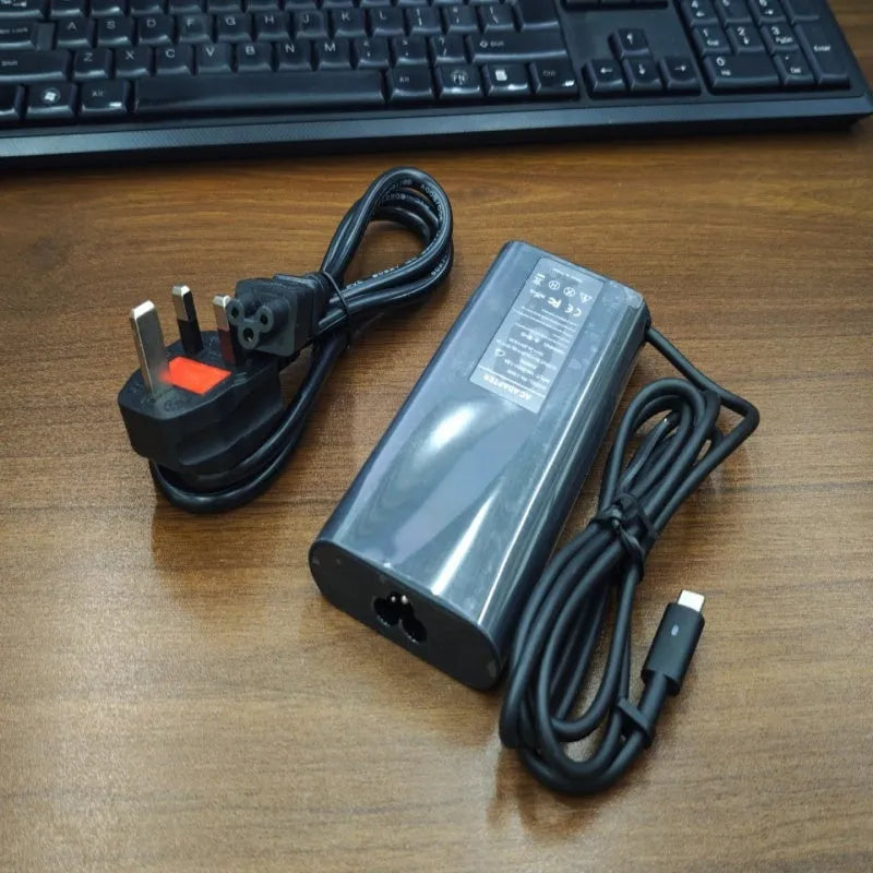 Black 65W USB-C laptop power adapter with six international plug cords for UK US EU AU SA and CN sockets