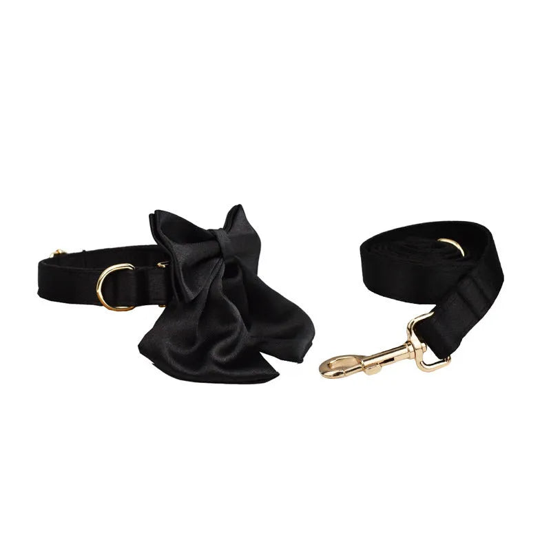 A cloth dog collar, matching leash, decorative bow, and dog vest set laid out flat, showing the coordinated design.