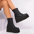Women's black wedge boot with round toe and high cylinder, showing waterproof platform sole.