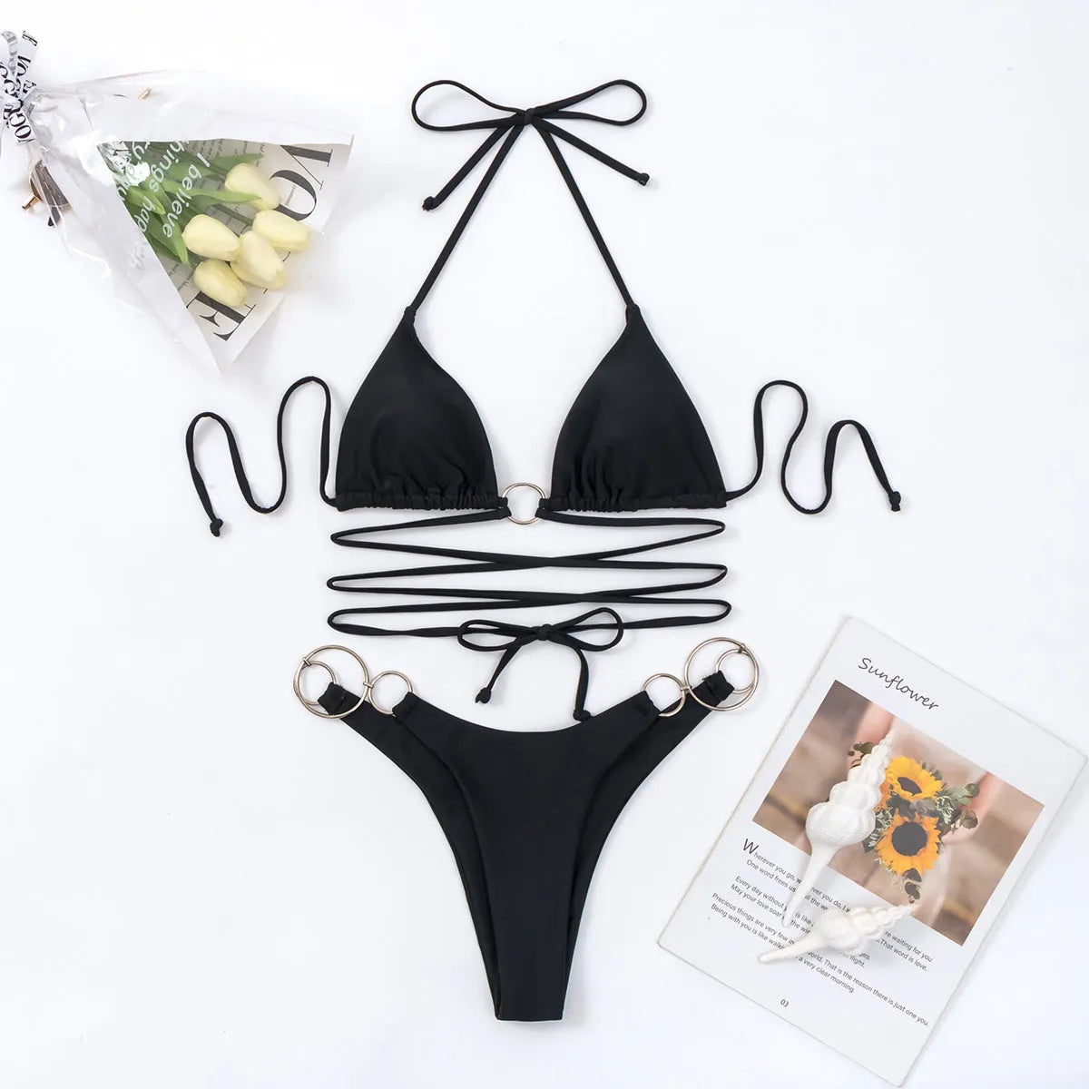 Black women's bikini set with metal ring accents on the adjustable straps, showing a high-cut leg and backless design.