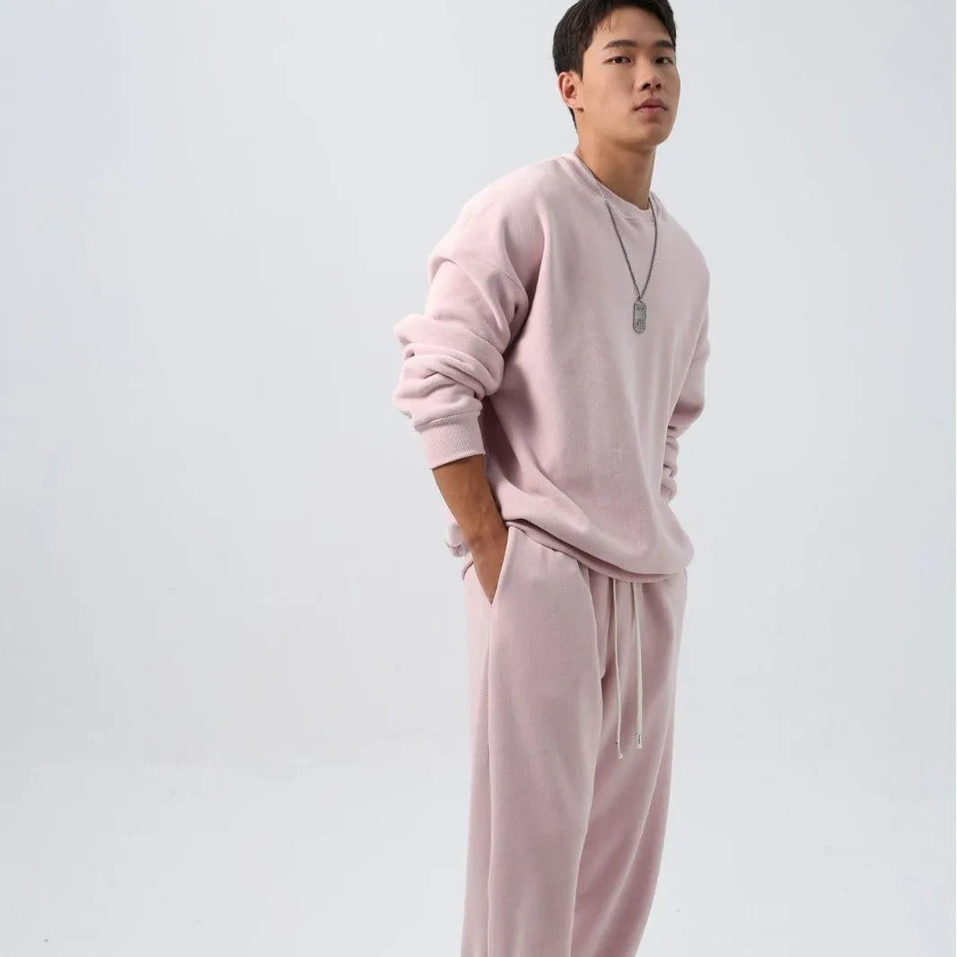 Men's black polar fleece sports suit with crew neck coat and matching trousers on a hanger.
