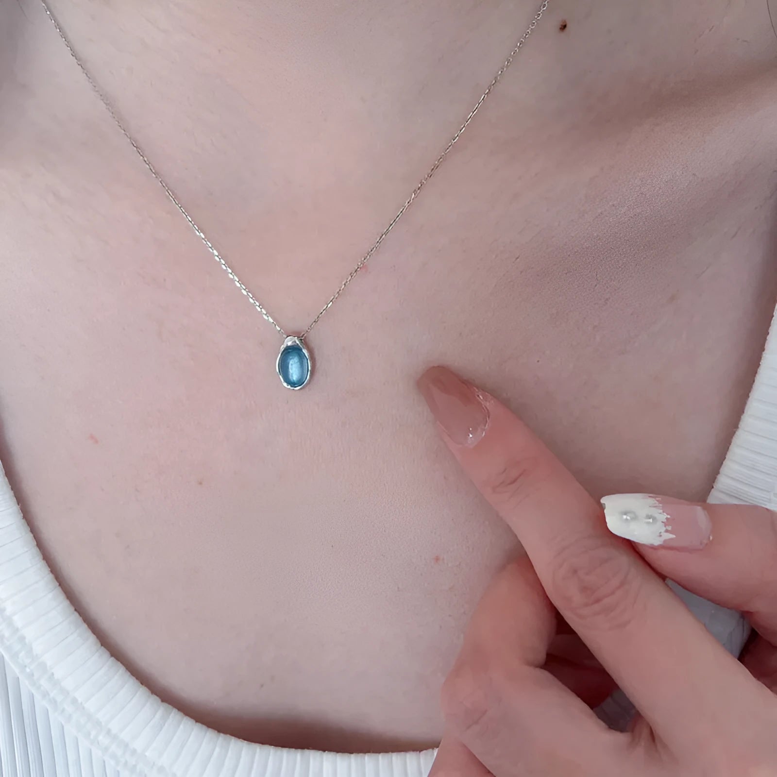 Navy blue and white gold geometric water drop pendant necklace on a cross chain for women.