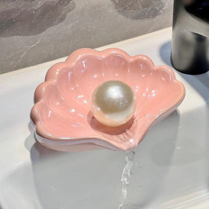 Shell-shaped white plastic soap dish with raised base for bathroom use
