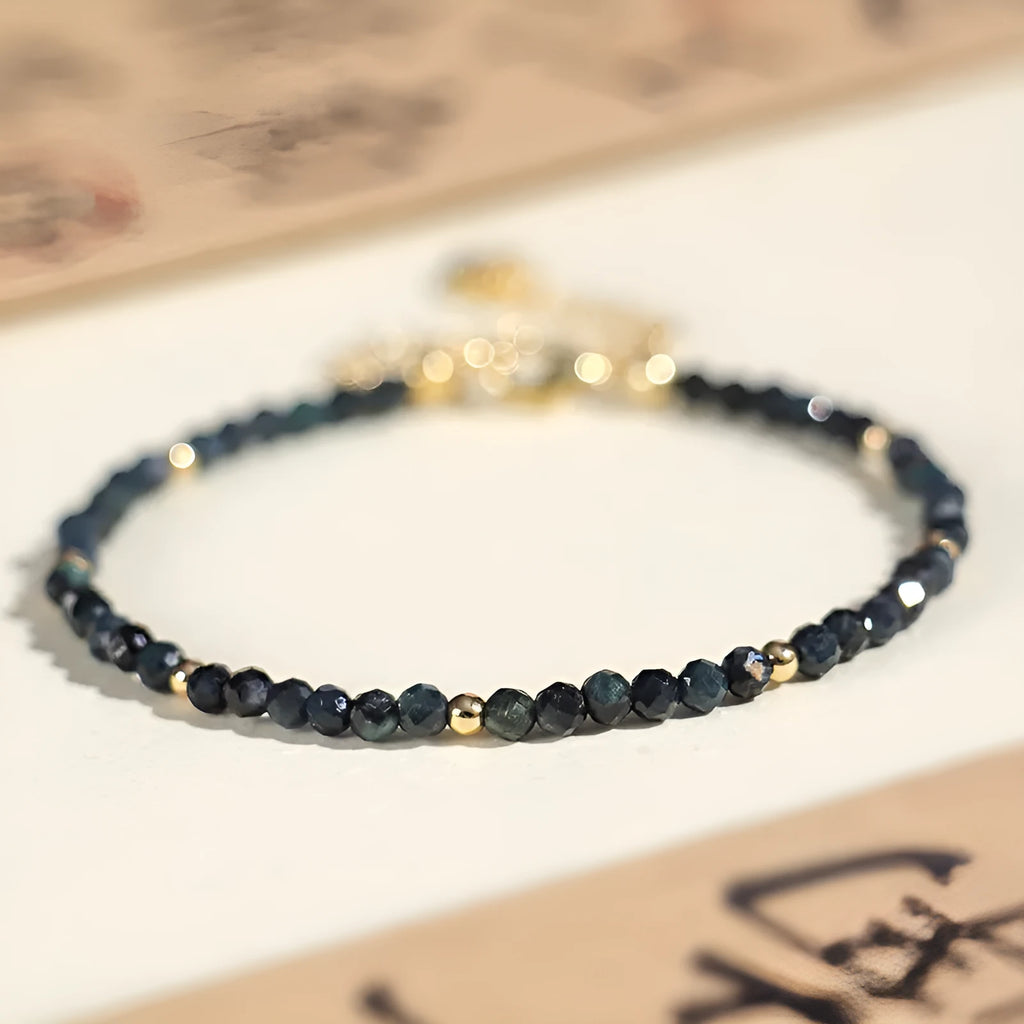 Blue tourmaline bracelet with 3mm beads and spacer beads on a wrist.