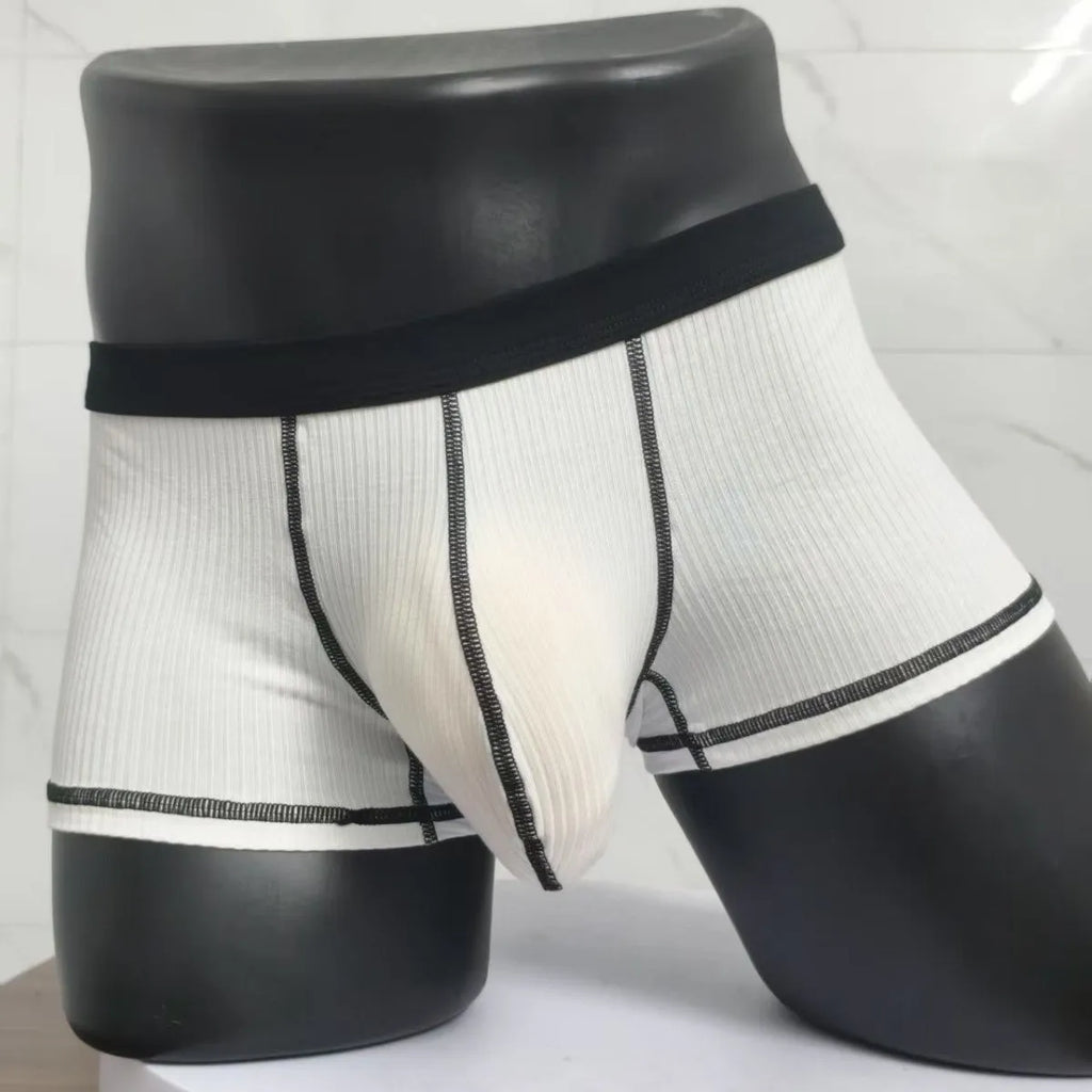 Men's solid colour boxer shorts in breathable fibre fabric on a plain background.