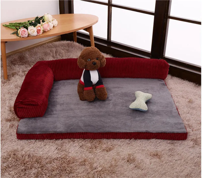 Corduroy pet sofa dog bed with a raised bolster, shown in a grey colour on a wooden floor.
