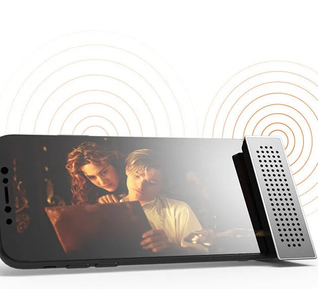 ABS mini mobile phone amplifier bracket in pink, holding a smartphone horizontally on a desktop.