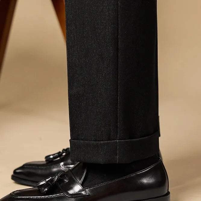 Men's black leather tassel loafers with rubber sole shown from side view