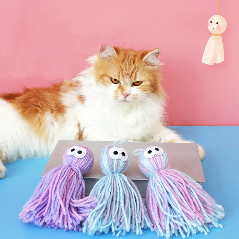Hanging wool ball cat toy with teaser stick in pink and blue colours on a white background.